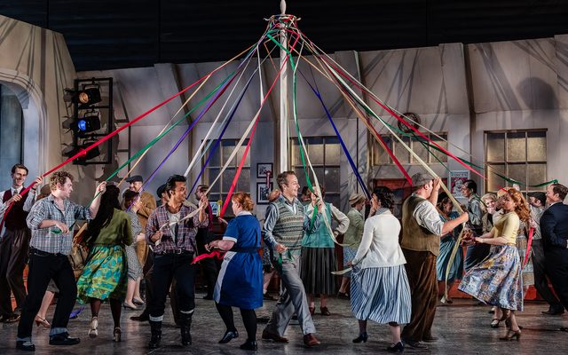 People in 1950s dress dance around a maypole. An image from Garsington Opera's 2023 performance of 'The Bartered Bride' by Smetana.