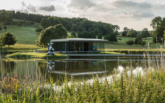 The island pavilion at Wormsley, seen across the beautiful lake and framed against the stunning Chiltern Hills.
