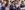 4-OperaFirst--Julian-Guidera-aspect-ratio-250-100 A group of children in purple school uniform stand singing around a piano.