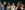 46-Dalia--Julian-Guidera-aspect-ratio-250-100 Girl wearing cricket sweater and white trousers running towards the front of the stage whilst smiling and surrounded by cheering friends.